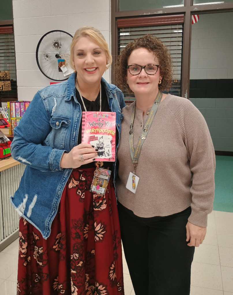 Teacher holding book they won from the Book Fair.