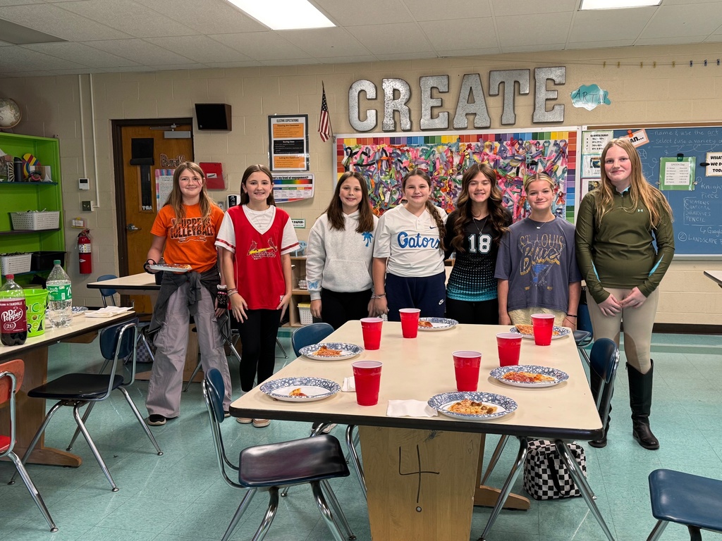 Students eating pizza and  celebrating.  