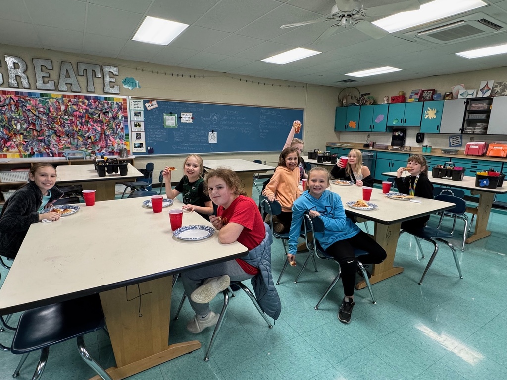 Students eating pizza and  celebrating.  