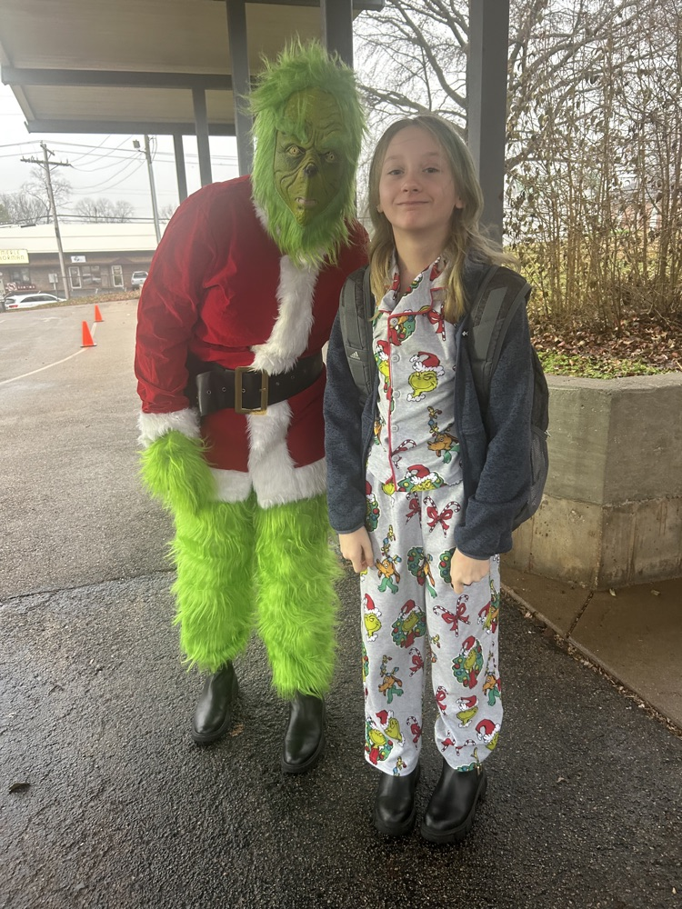 Students wearing pajamas standing with the Grinch