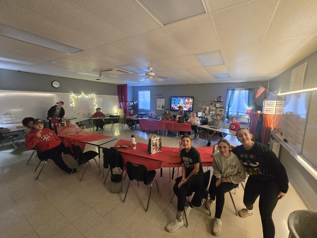 Students enjoying a holiday breakfast.  The classroom is decorated for the holidays.  