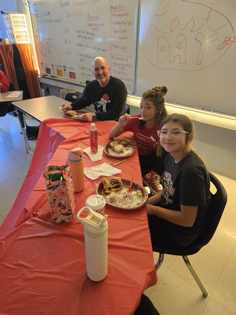 Students enjoying a holiday breakfast.  The classroom is decorated for the holidays.  