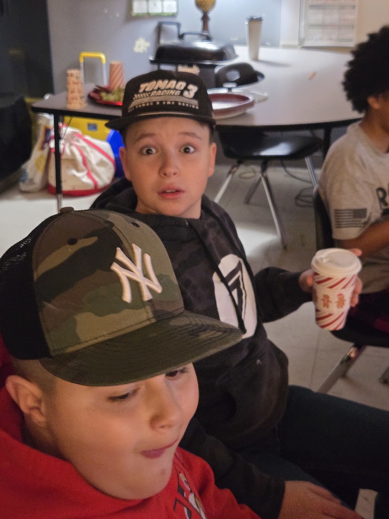 Students enjoying a holiday breakfast.  The classroom is decorated for the holidays.  