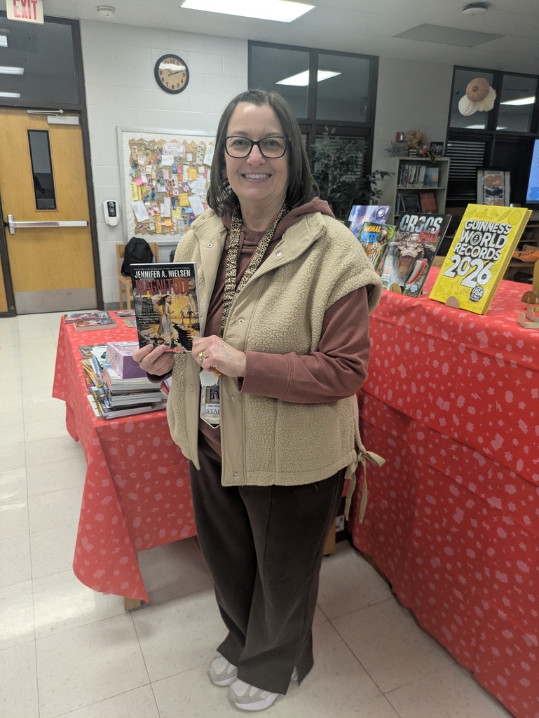 Teacher smiling and holding a new book.