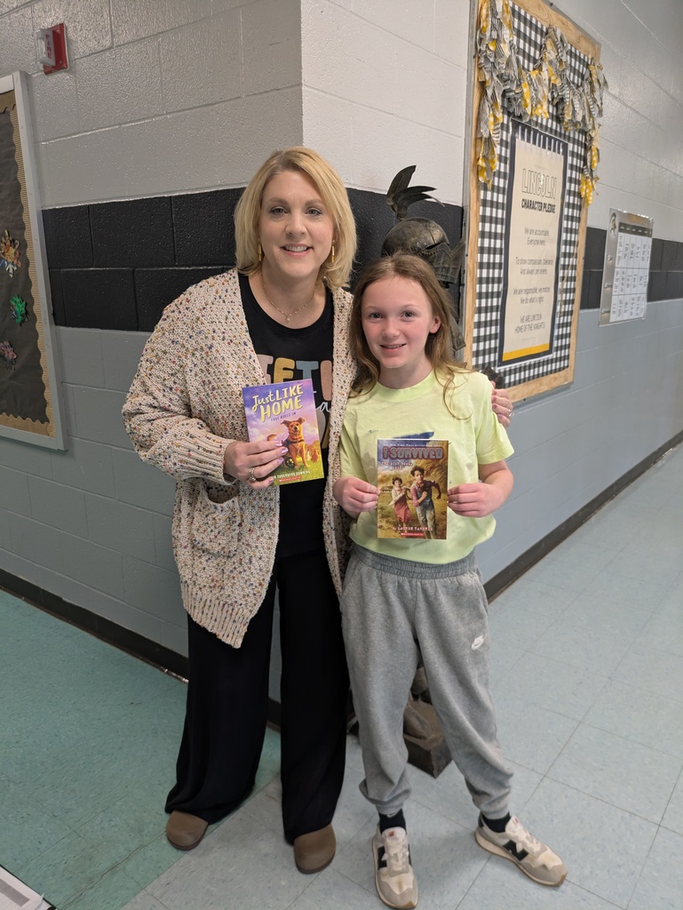 Teacher and student smiling and holding new books.