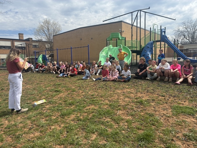 third graders reading outside with Ms. Morris
