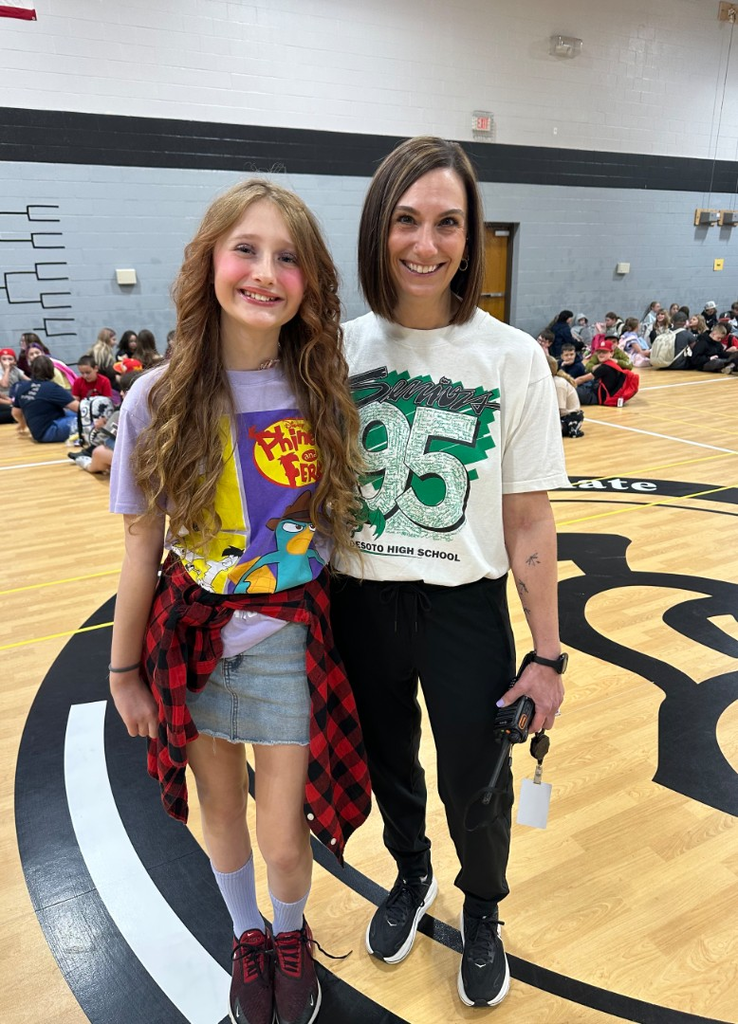 Student and principal smiling in 90's clothes.