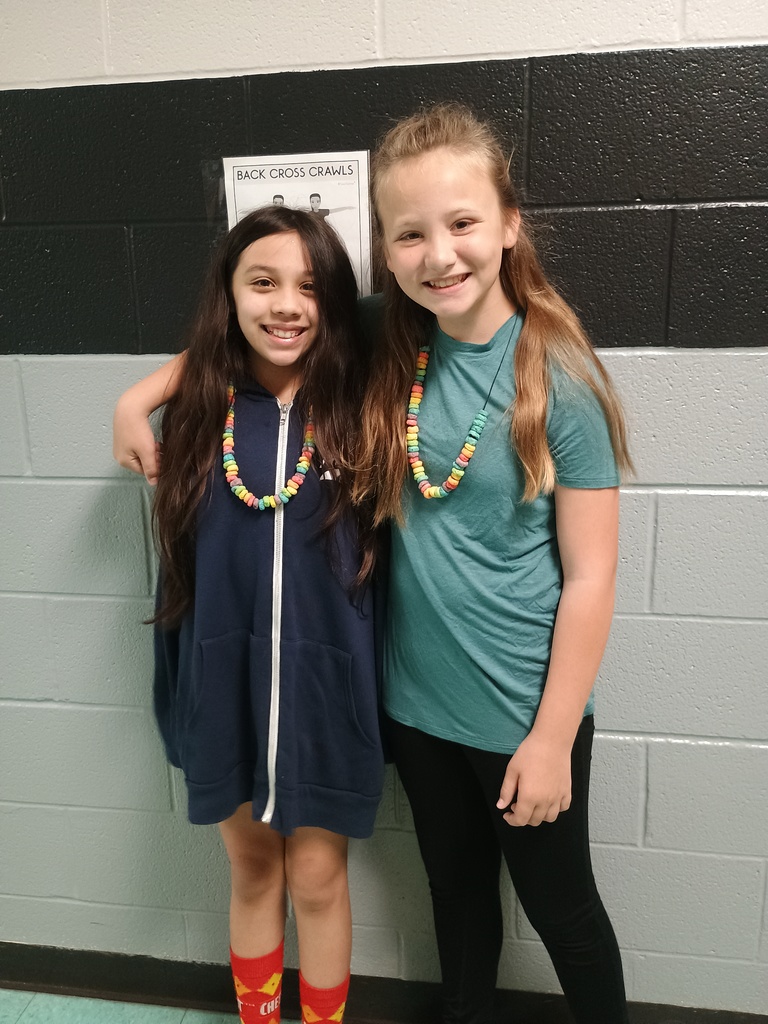 Students smiling with necklaces they made.