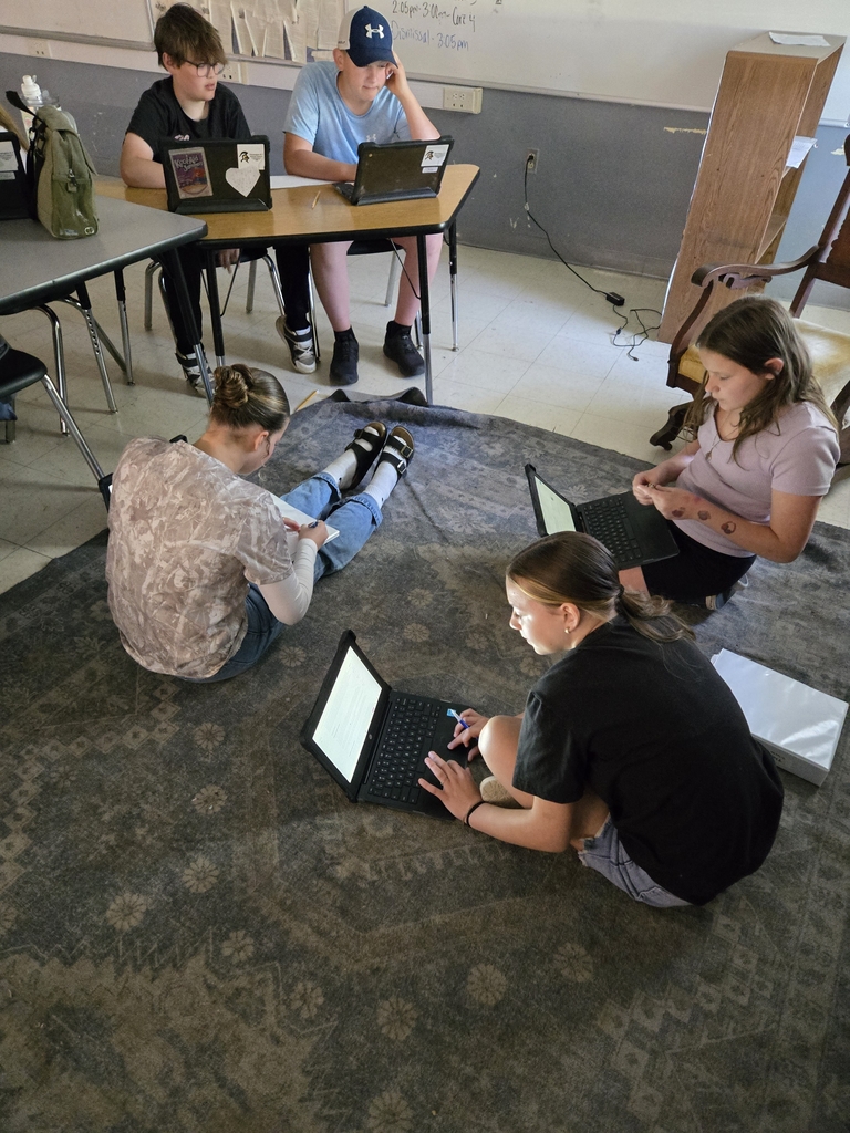 Students in a classroom sit at desks using chromebooks to participate in a virtual tour of Medieval England. One student’s screen shows a historical map, while others work together to translate Old English text.