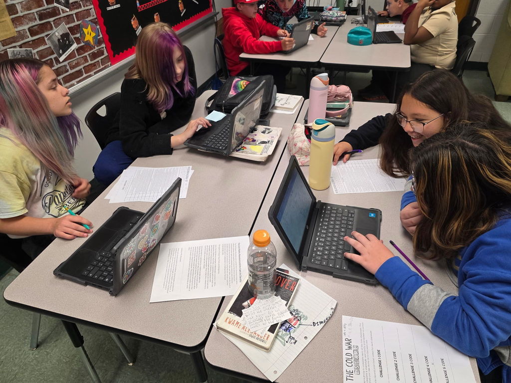 Students working in groups to complete an escape room activity. 