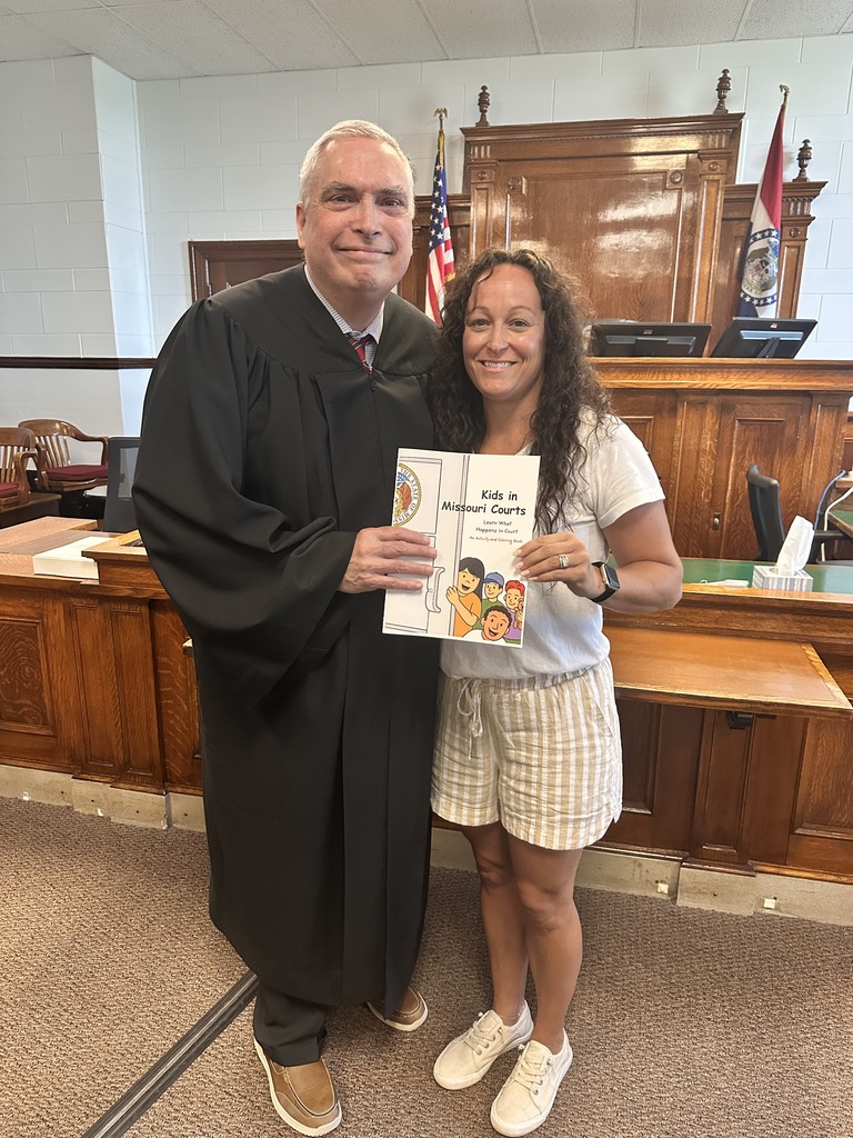 Keli Keutzer and Judge Patrick King with the children's book they had published