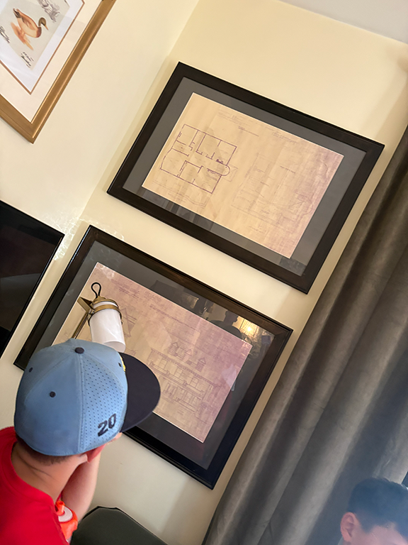 Boy looking at old renderings of historic home