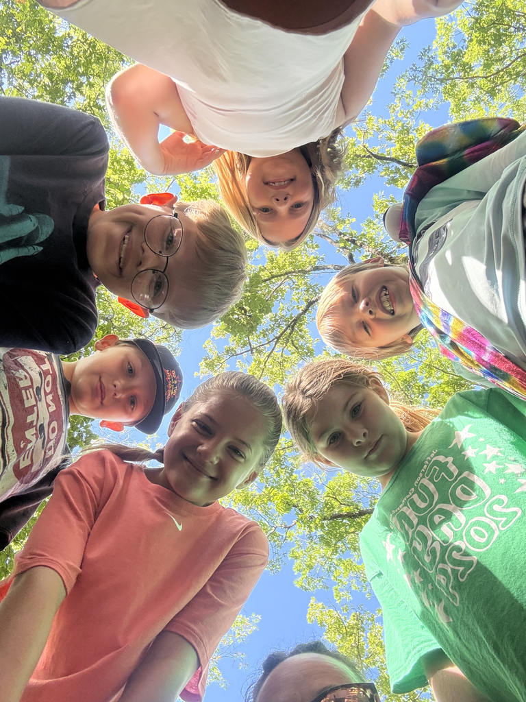 Kids in a circle standing over a camera