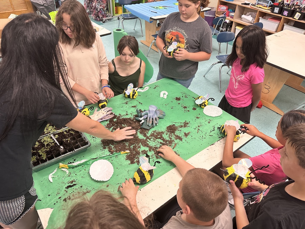 Kids filling flower pots with dirt