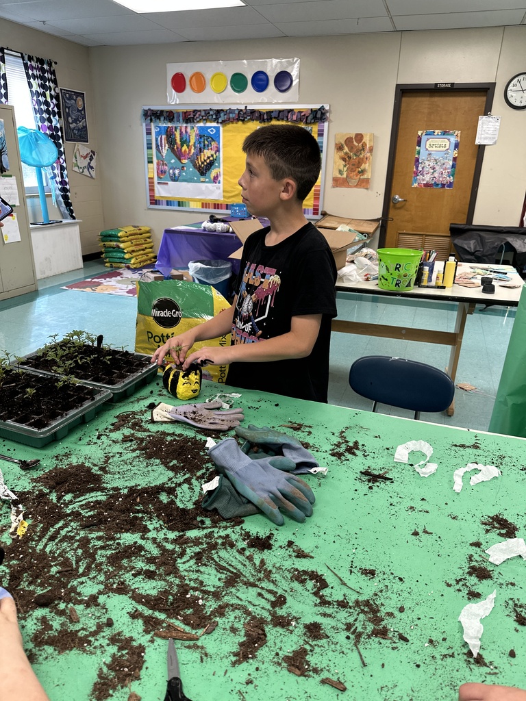 Boys filling a flower pot with dirt