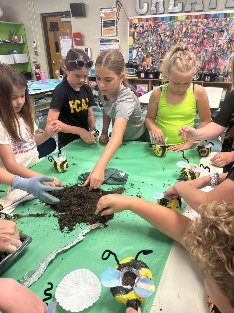 Kids filling flower pots with dirt