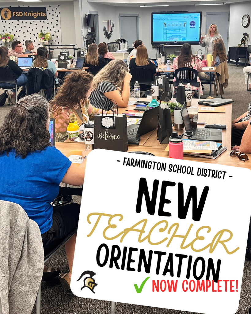 People in a room with tables, laptops, and monitors. A sign reads "NEW TEACHER ORIENTATION NOW COMPLETE!"