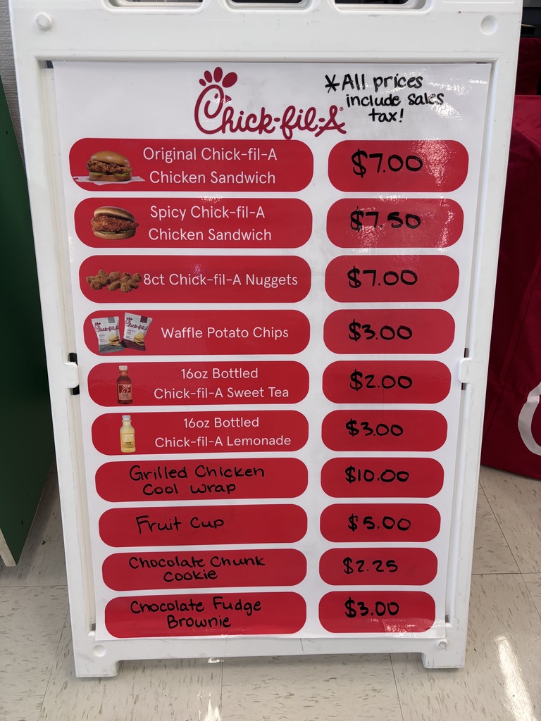 A white menu board with a red border lists various food items and their prices. Background: A red object.