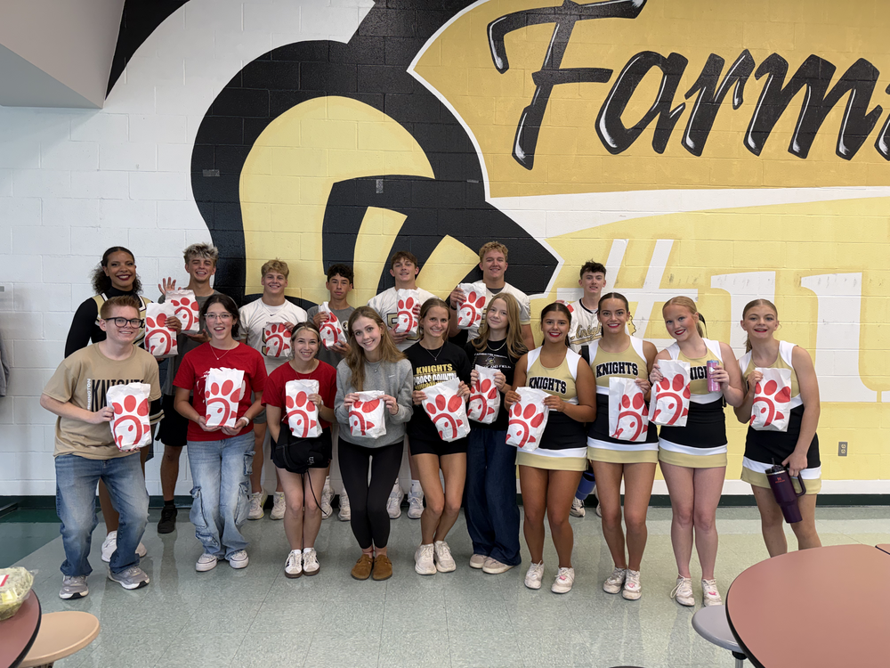 Group of young people holding red bags, standing in front of a Farm sign on a wall.