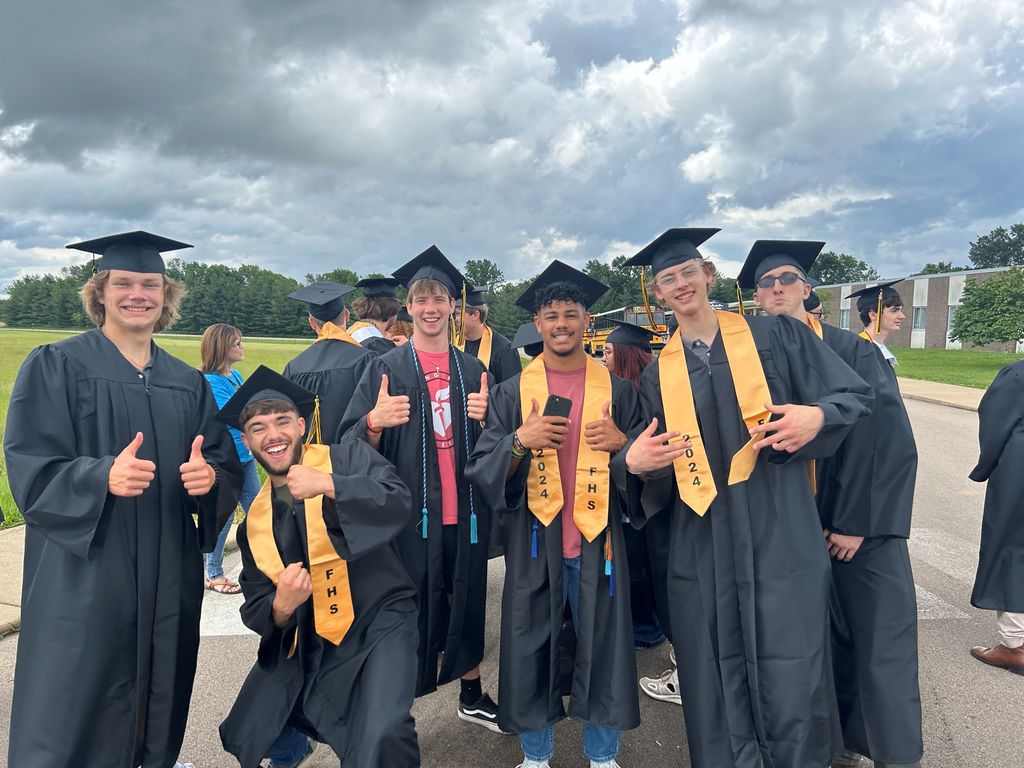 students in caps and gowns smiling