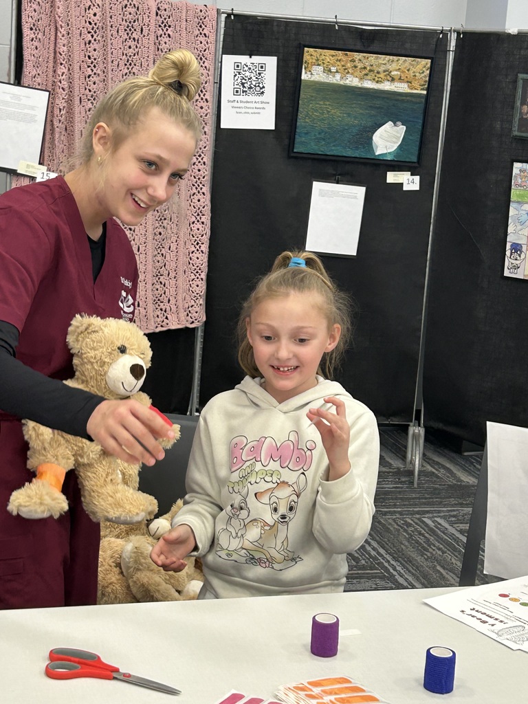 CTE STUDENT AND 1ST GRADE GIRL AT CTE MAGNUS CENTER TEDDY BEAR CLINIC 
