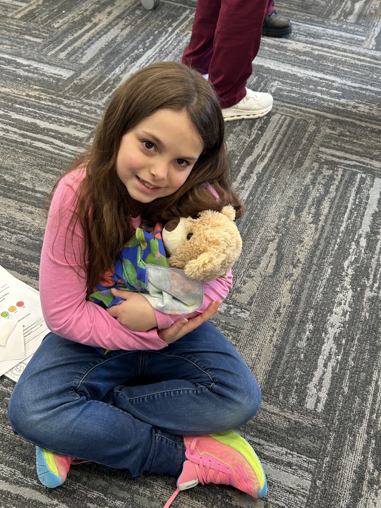 FIRST GRADE GIRL HOLDING TEDDY BEAR AT CTE MAGNUS CENTER TEDDY BEAR CLINIC 
