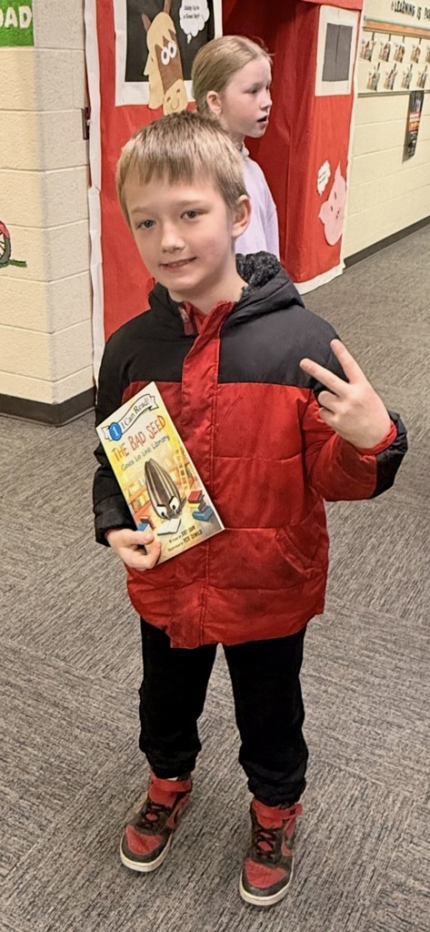 Male Kindergarten Student Holding Book that they won from the book vending machine for being a good seed 
