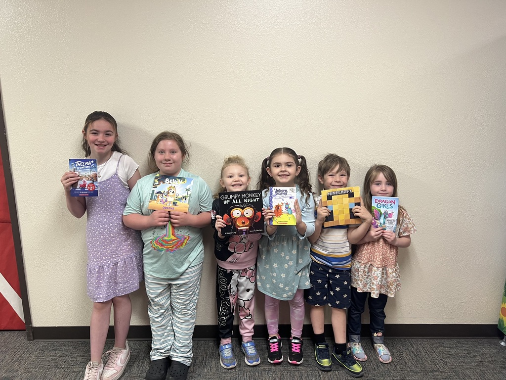 ELEMENTARY STUDENTS WITH BOOKS FROM BOOK MACHINE FOR GOOD BEHAVIOR AND BEING GOOD SEEDS 2026