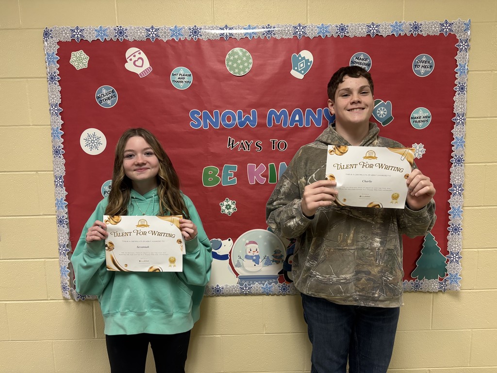 Student displaying their certificate for winning the writing contest. 