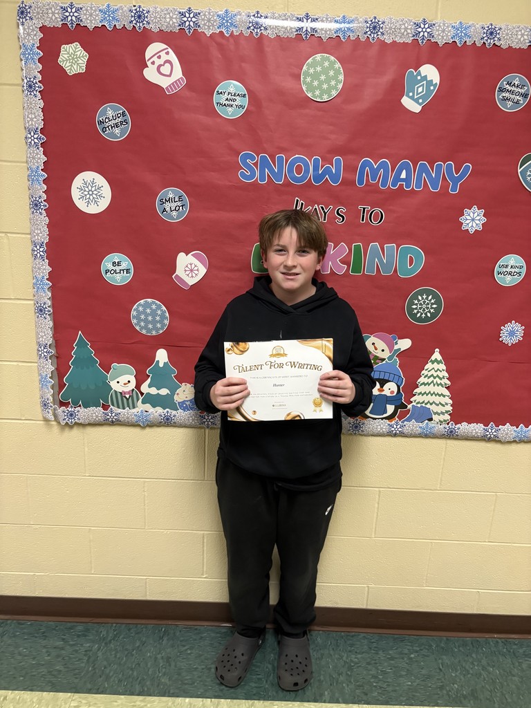 Student displaying their certificate for winning the writing contest. 