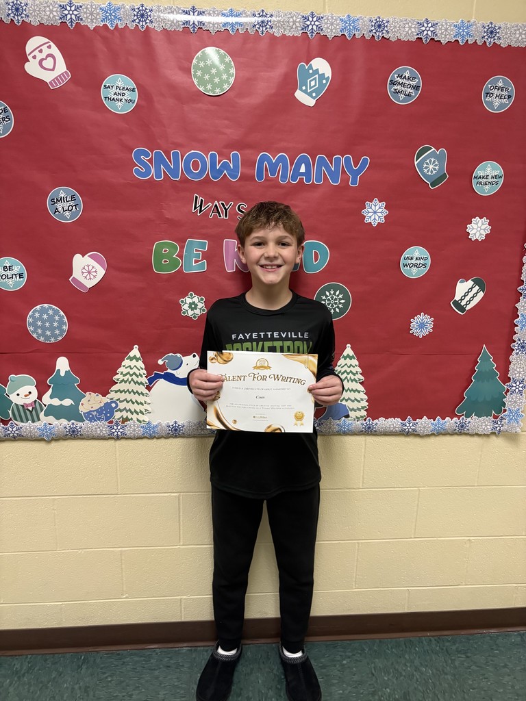 Student displaying their certificate for winning the writing contest. 