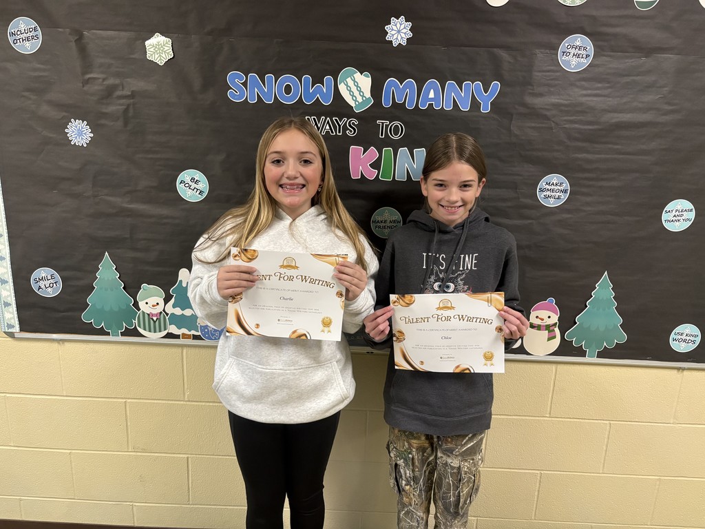 Student displaying their certificate for winning the writing contest. 