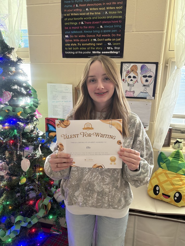 Student displaying their certificate for winning the writing contest. 