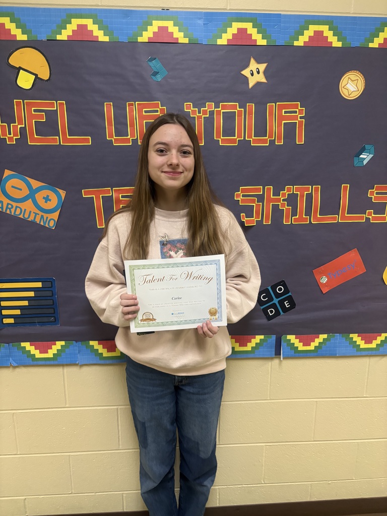 Student displaying their certificate for winning the writing contest. 