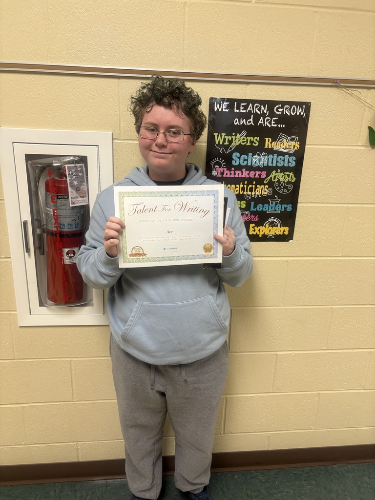 Student displaying their certificate for winning the writing contest. 