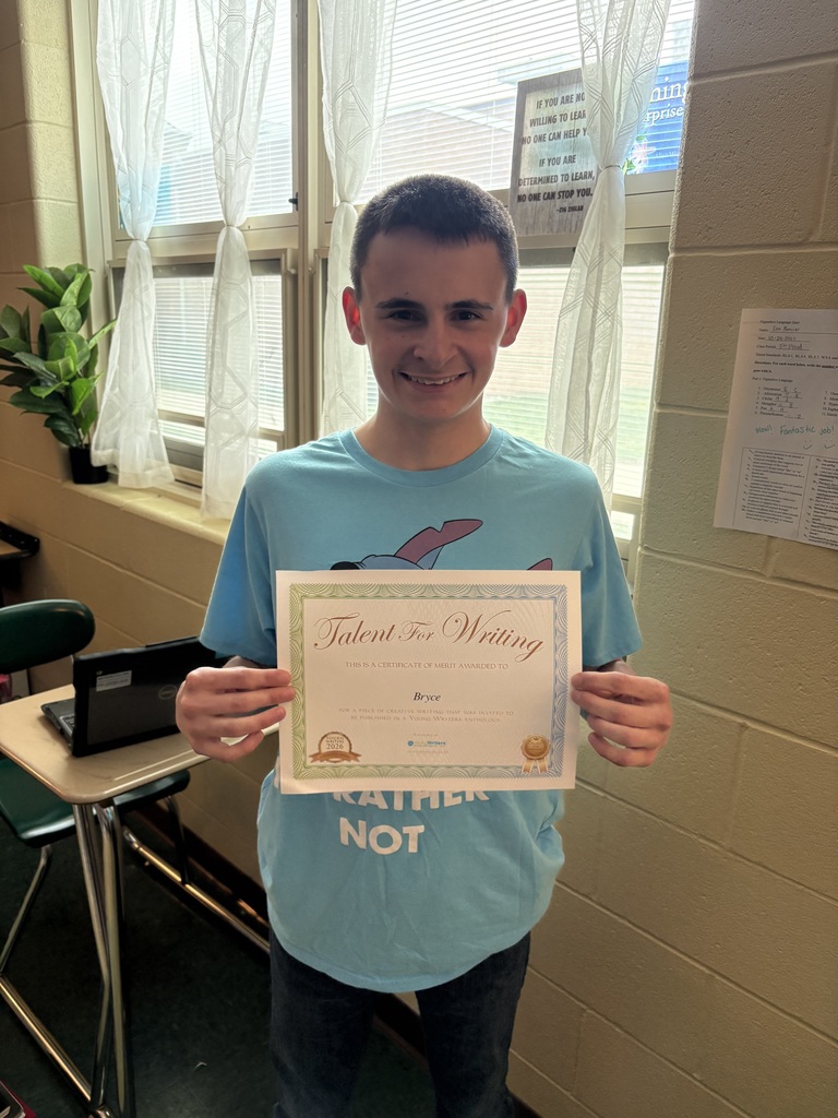 Student displaying their certificate for winning the writing contest. 