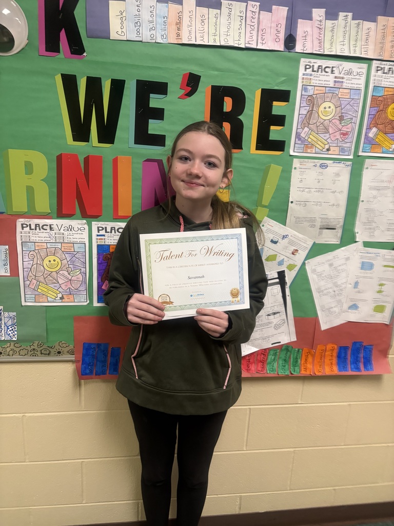 Student displaying their certificate for winning the writing contest. 