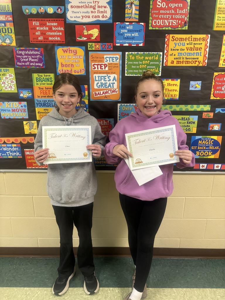 Student displaying their certificate for winning the writing contest. 