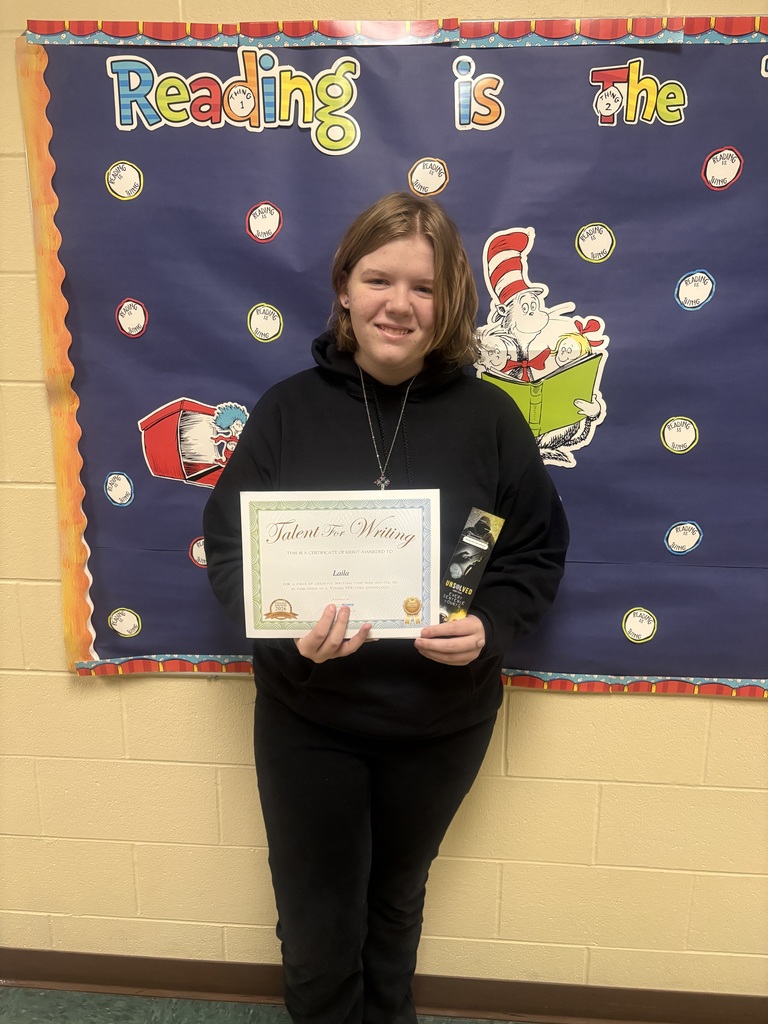 Student displaying their certificate for winning the writing contest. 