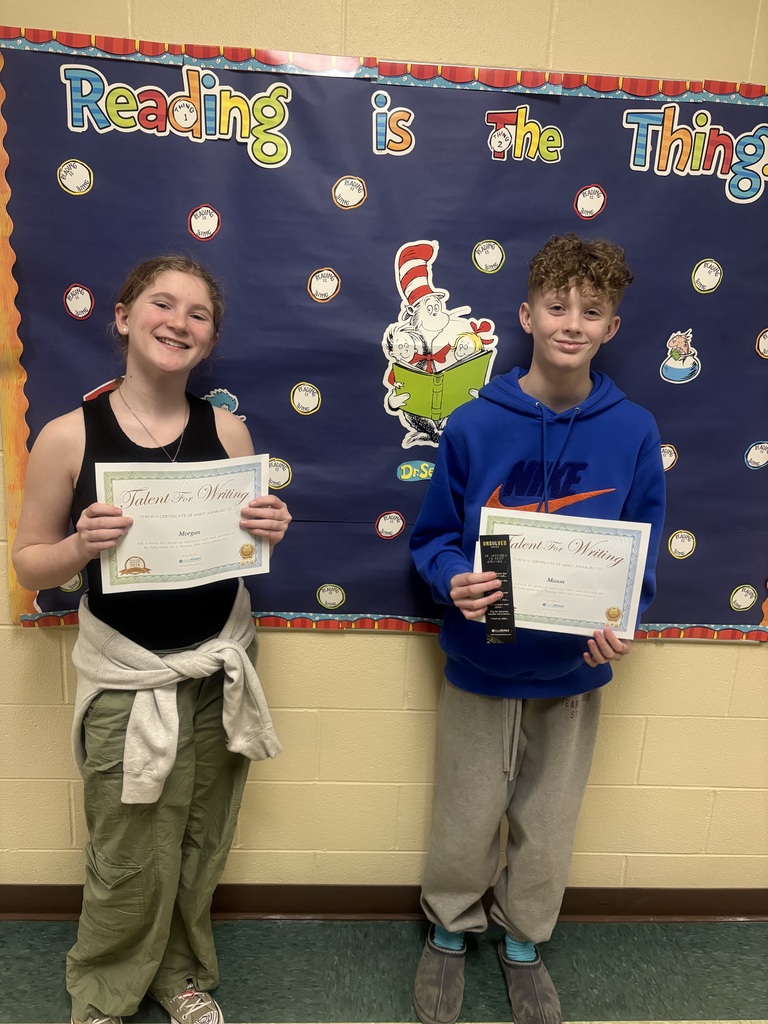 Student displaying their certificate for winning the writing contest. 