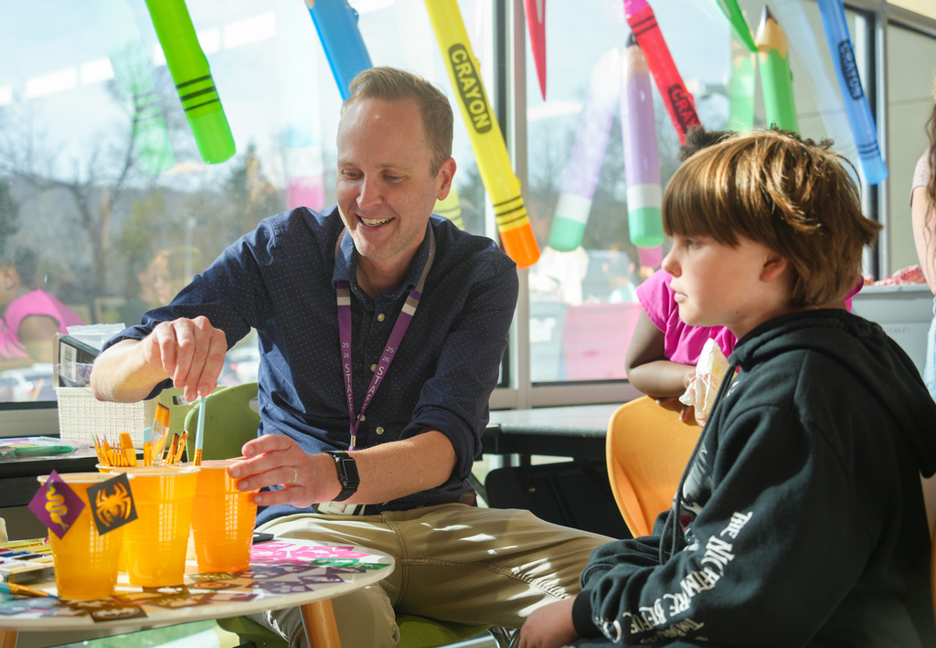 Families participating in activities and viewing student art at the Happy Hollow Art Show.