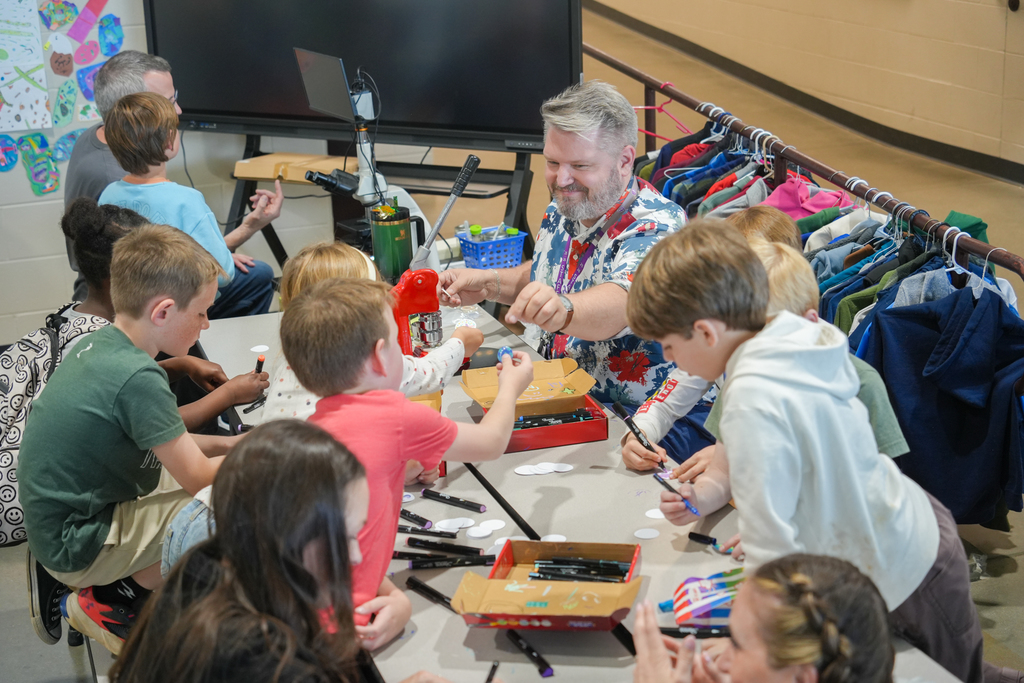 Families participating in activities and viewing student art at the Happy Hollow Art Show.