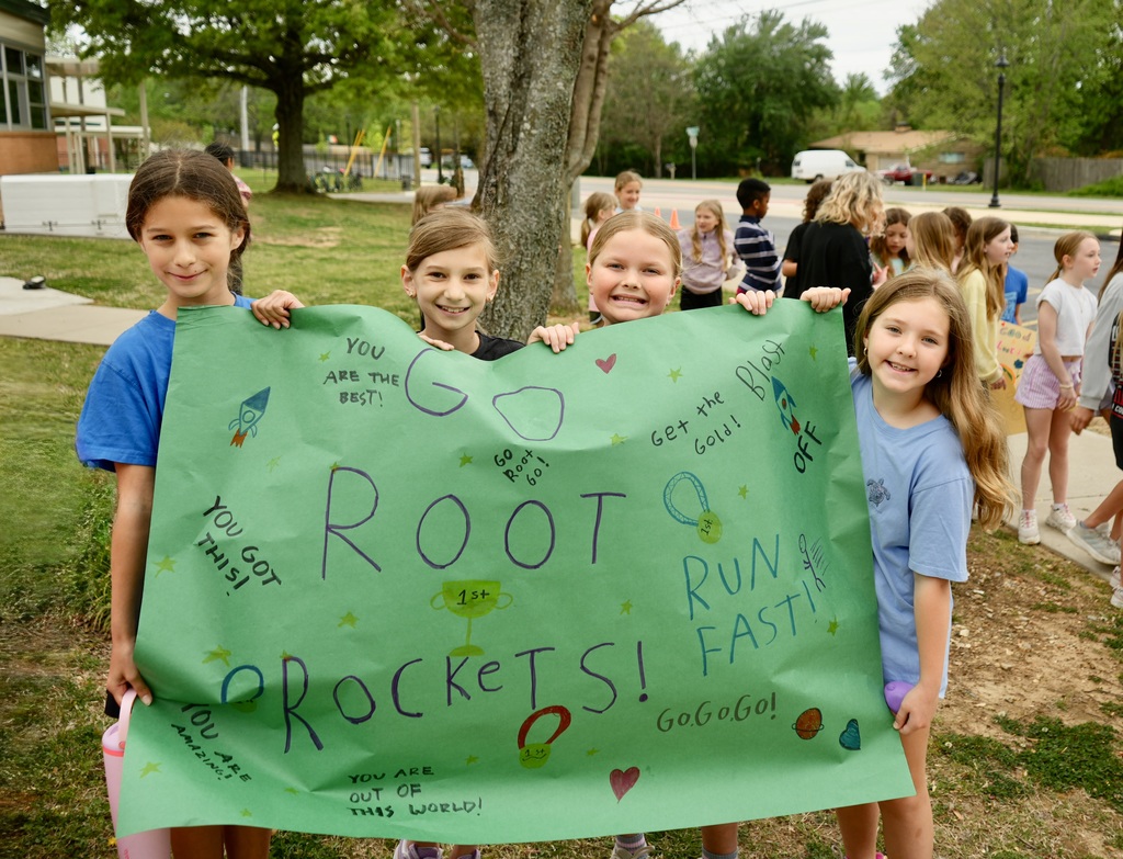 Girls holding a green sign.