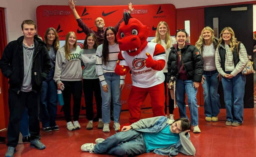 Students standing with the mascot.