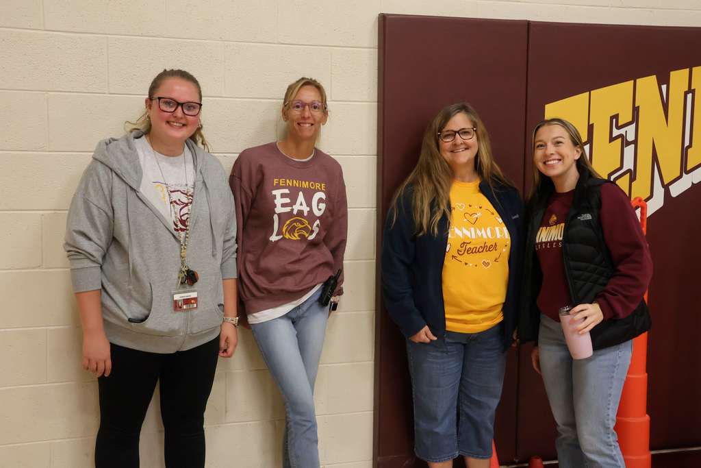 A team of teachers for pose for a picture in the gym