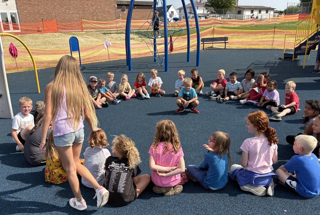 K-3 students play duck duck goose on playground