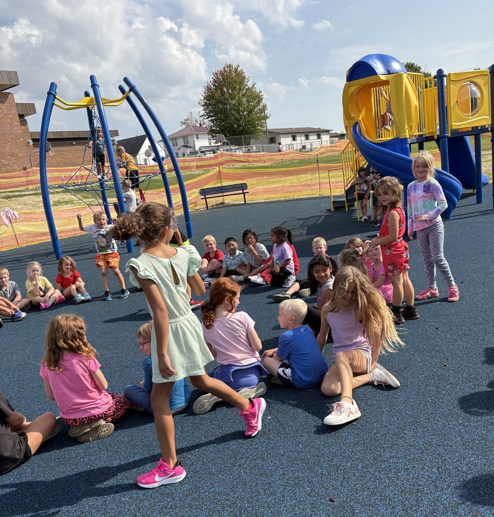 K-3 students play duck duck goose on playground