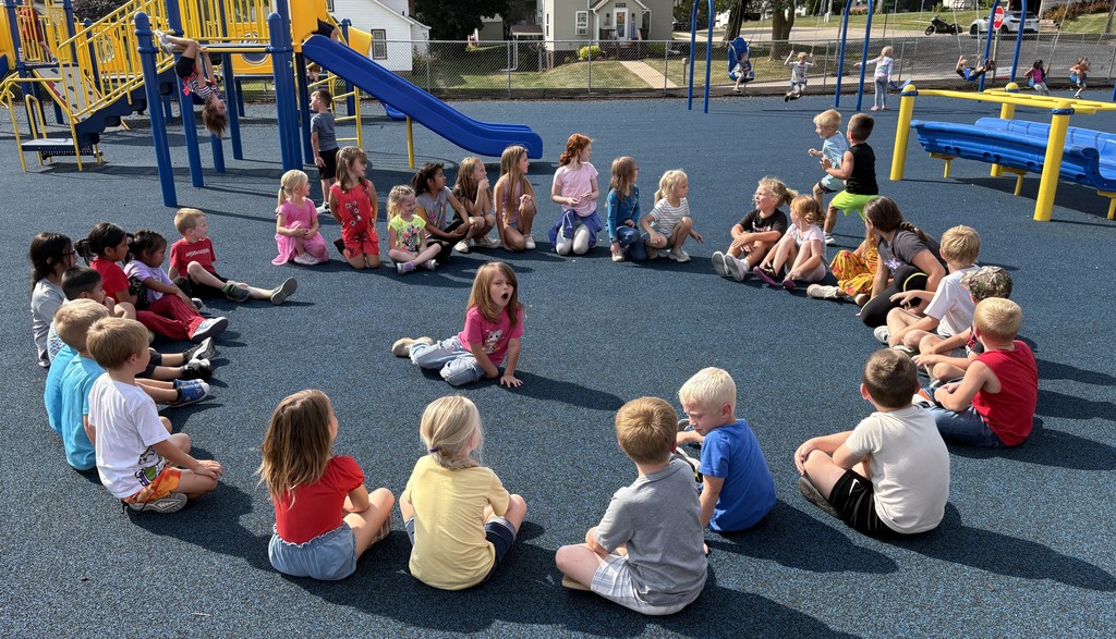 K-3 students play duck duck goose on playground
