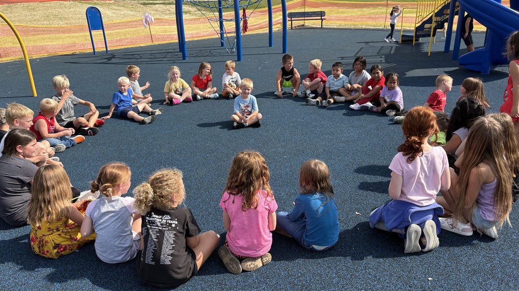 K-3 students play duck duck goose on playground