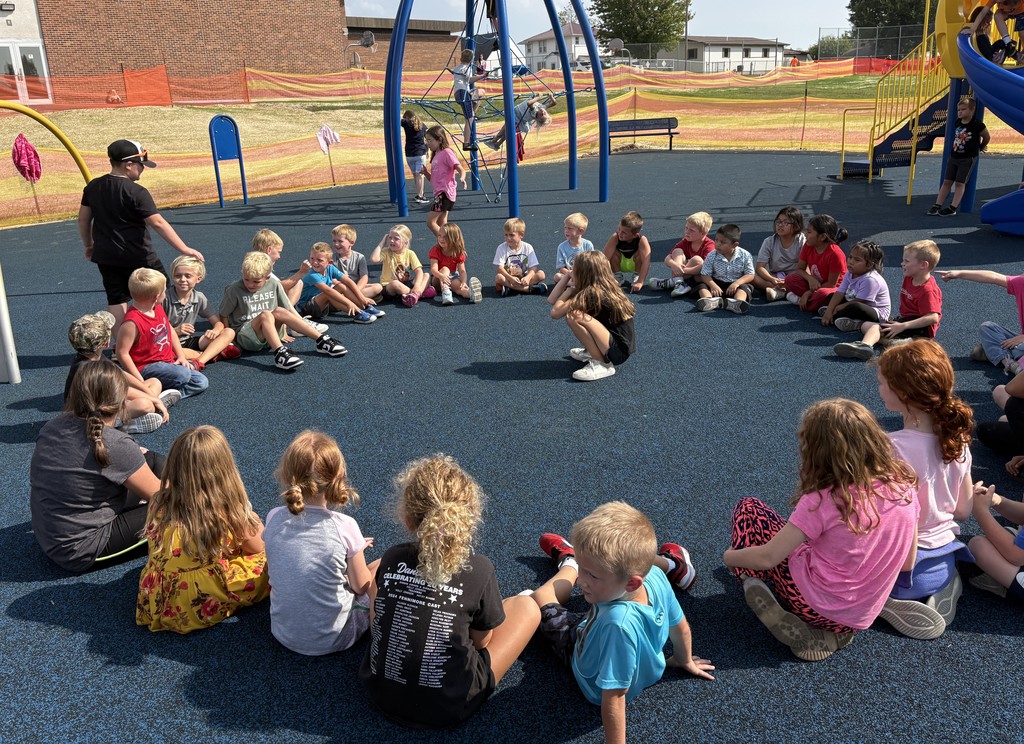 K-3 students play duck duck goose on playground